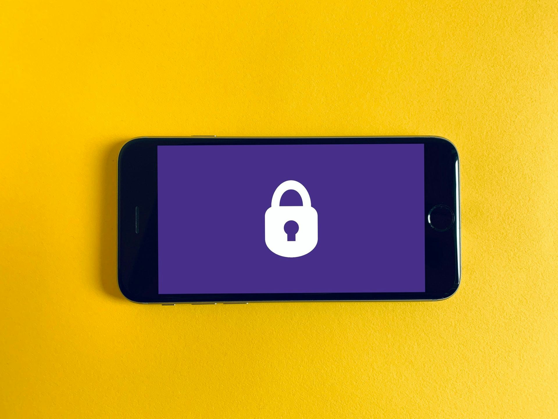 Photo of a white lock icon on a purple fullscreen background displayed on a cellphone screen